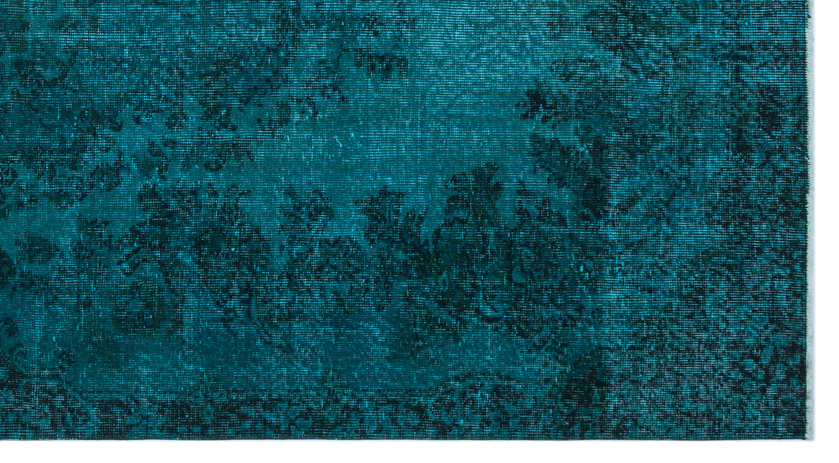 Teal and black rug with a distressed, faded traditional floral medallion pattern.