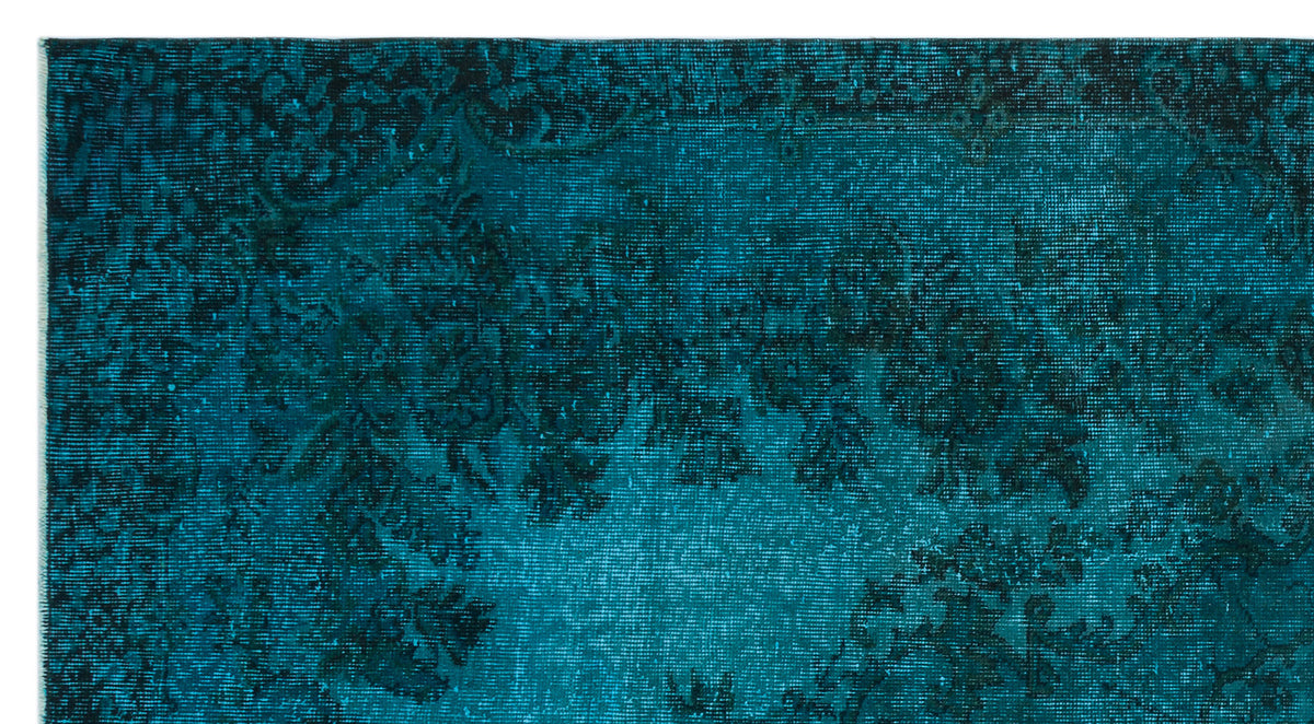 Teal and black distressed rug with a traditional floral medallion pattern.