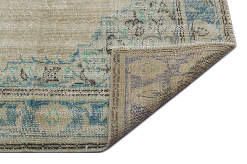 Load image 1 in gallery view. Beige and blue distressed traditional rug with a folded corner showing the reverse side on a white background.
