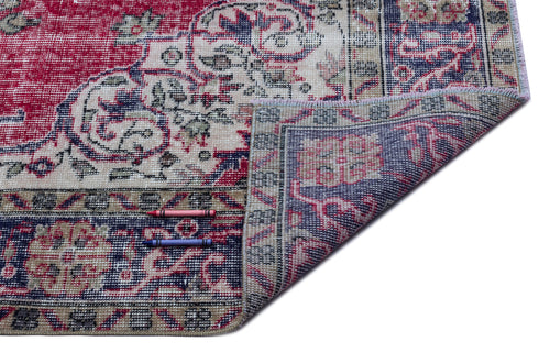 Load image 1 in gallery view. Distressed red, navy, and cream traditional medallion rug with a folded corner, shown on a white background.
