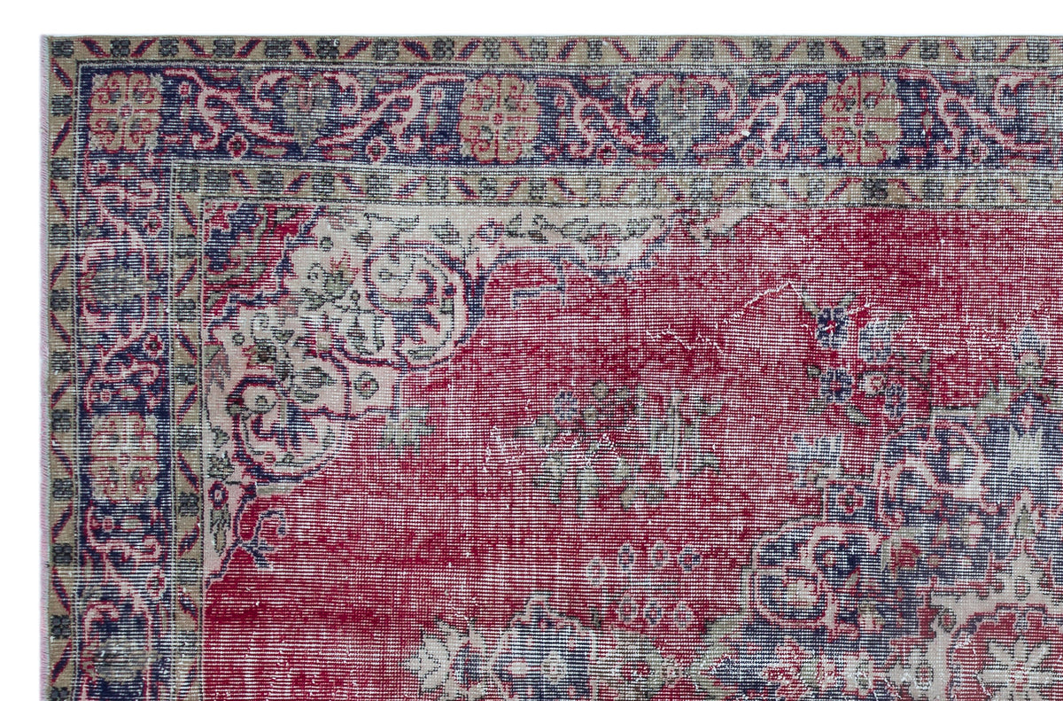 Distressed red, navy, and beige traditional rug with an ornate floral medallion pattern and a detailed border.