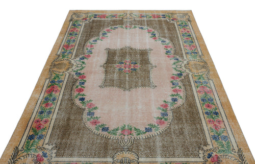 Load image 1 in gallery view. Distressed brown and pink vintage-style rug with a central floral medallion and decorative floral border.