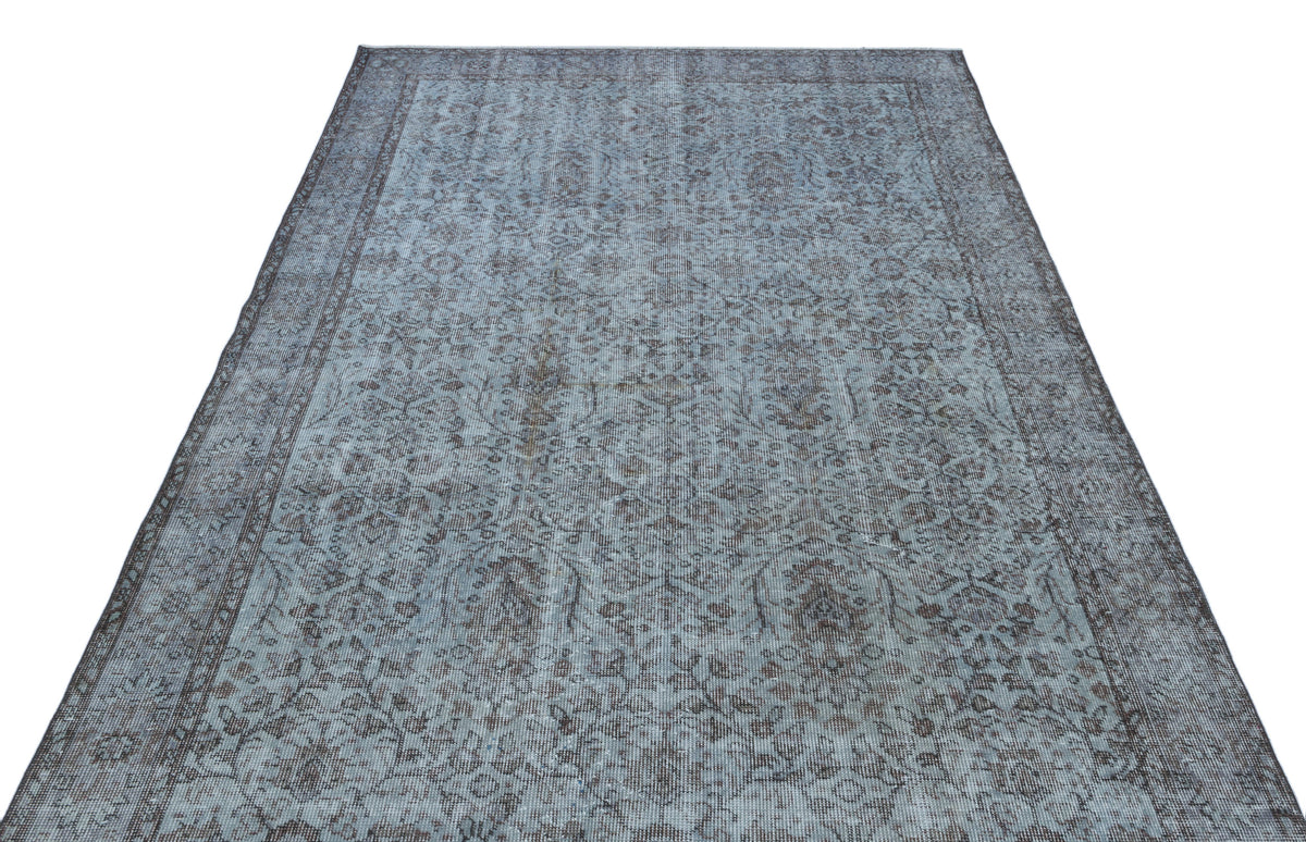 Blue and charcoal grey vintage-style rug with a distressed floral medallion pattern on a white background.