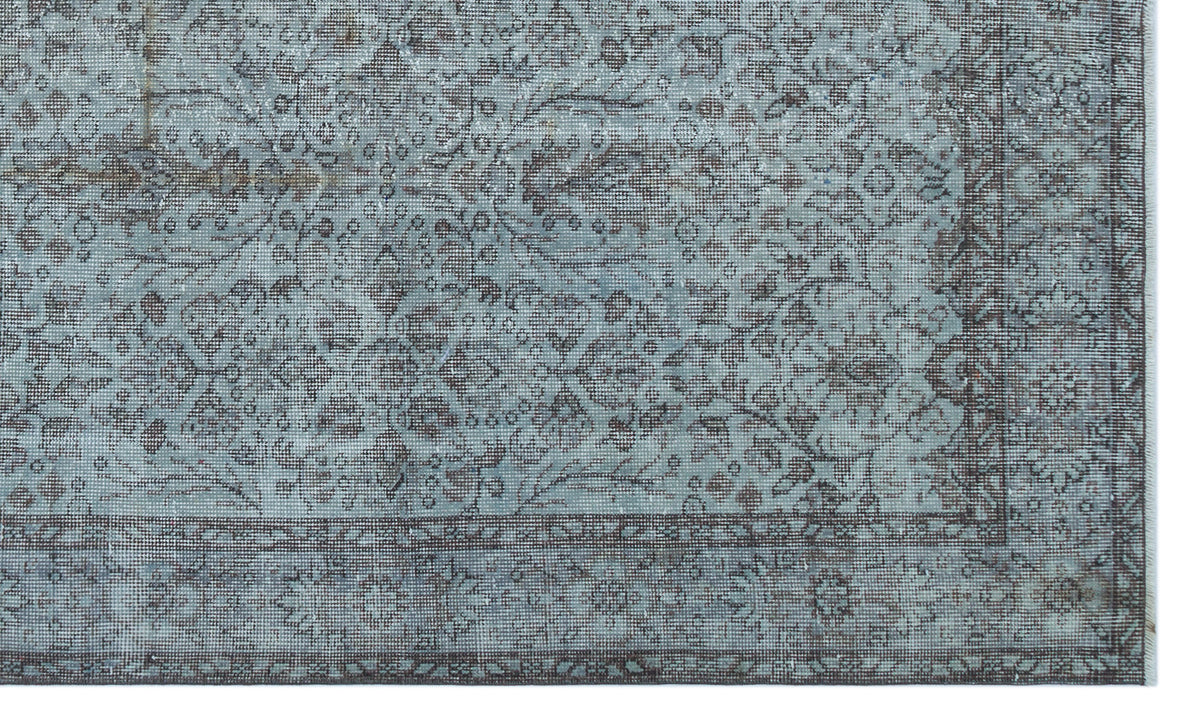 Distressed blue and charcoal grey rug with a traditional floral medallion pattern and a detailed border.