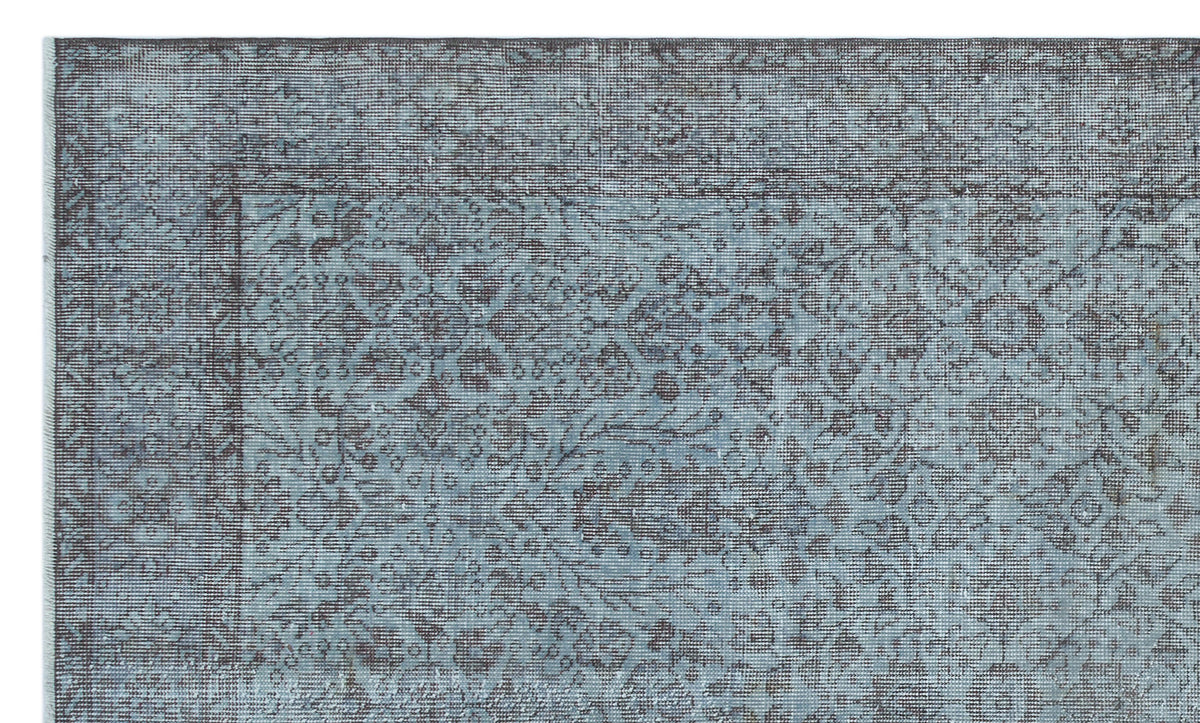 Blue and charcoal grey distressed rug with a traditional ornate floral medallion pattern.