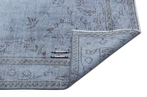 Load image 1 in gallery view. Light blue and grey distressed traditional rug with a floral medallion pattern, shown with a corner folded over.