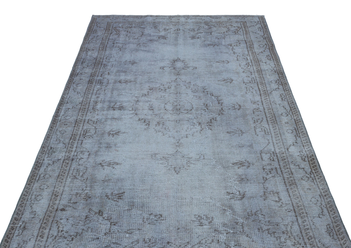 Light gray and taupe distressed vintage-style rug with a central medallion and ornate border pattern.