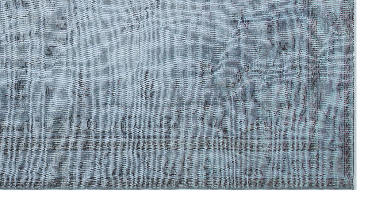 Light blue rug with a distressed, faded traditional medallion pattern and a bordered edge.