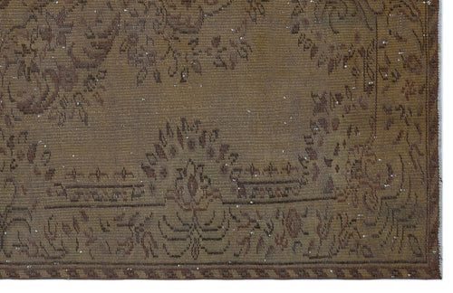 Load image 1 in gallery view. Brown distressed rug with a faded traditional floral medallion pattern and a geometric border.
