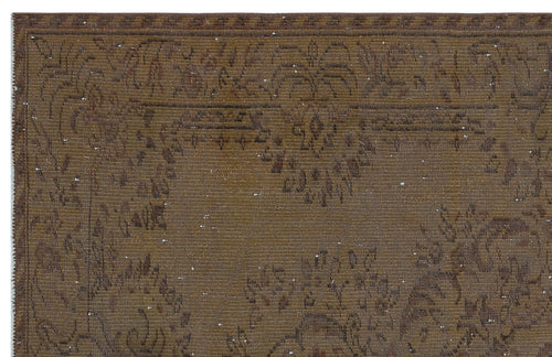 Load image 1 in gallery view. Brown distressed rug with a faded traditional floral medallion pattern and a geometric border.