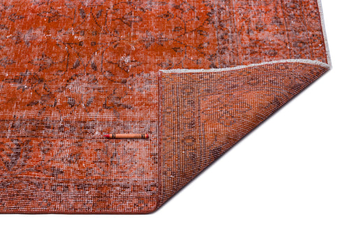 Load image 1 in gallery view. Distressed burnt orange rug with a faded floral pattern and a folded corner, isolated on a white background.