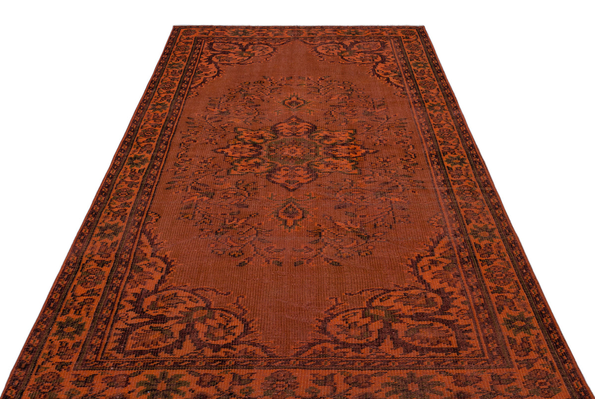 Rust-colored traditional rug with a dark brown central floral medallion and ornate border pattern on a white background.