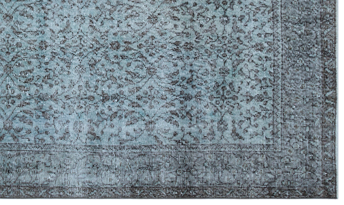 Light blue and charcoal grey rug with a distressed traditional floral medallion pattern and a wide border.