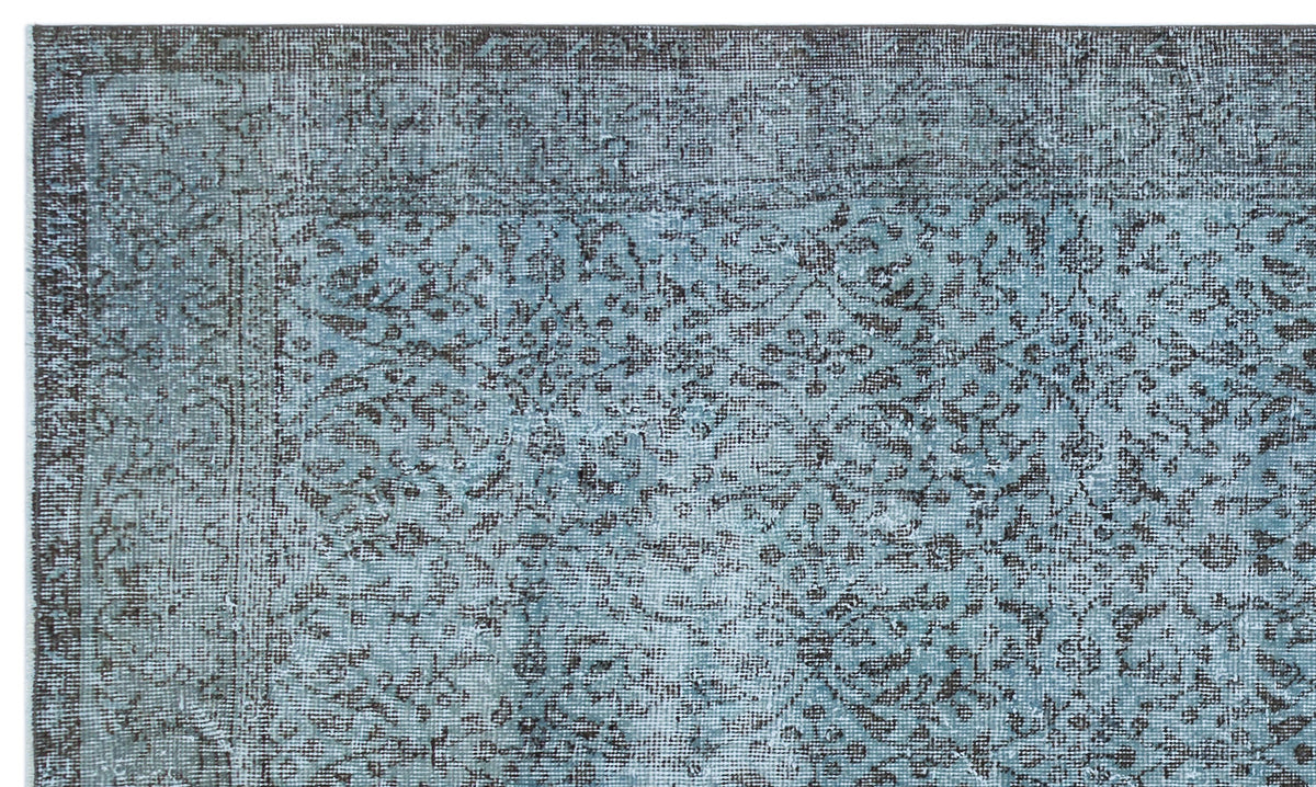 Distressed blue and charcoal grey rug with a traditional floral medallion pattern and a detailed border.