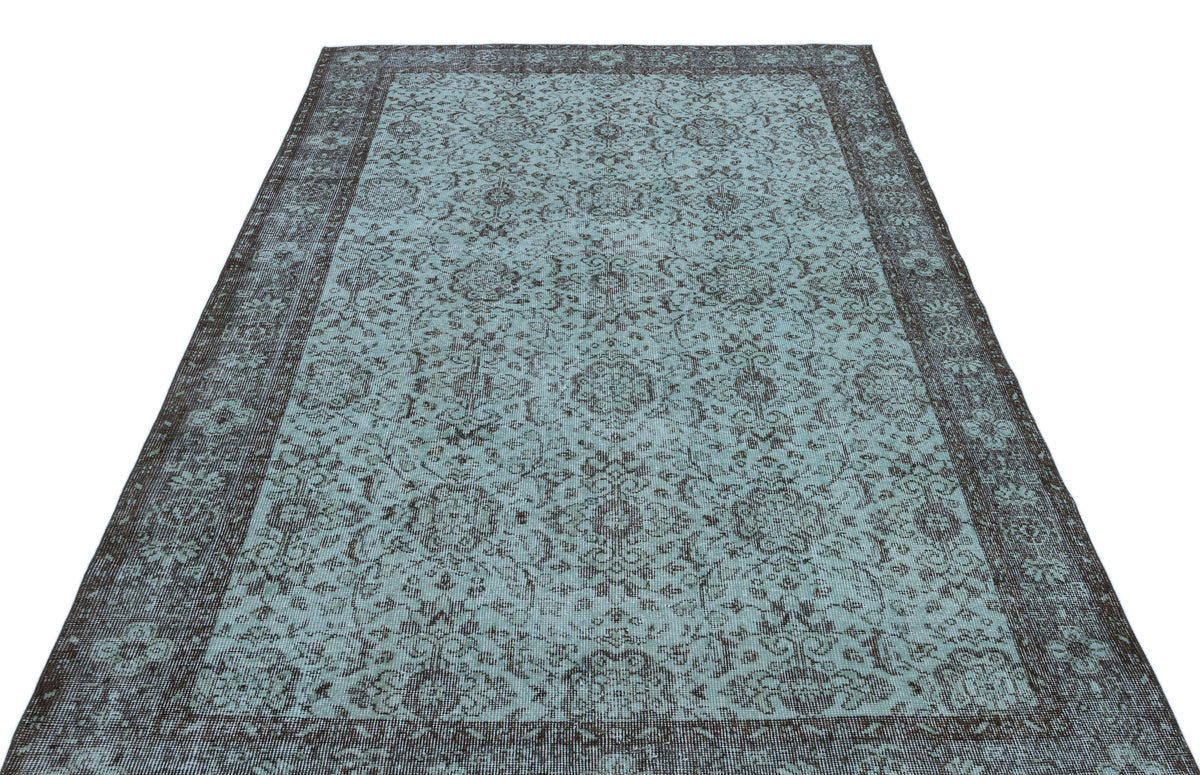 Teal and charcoal distressed rug with a traditional floral medallion pattern and a wide decorative border.