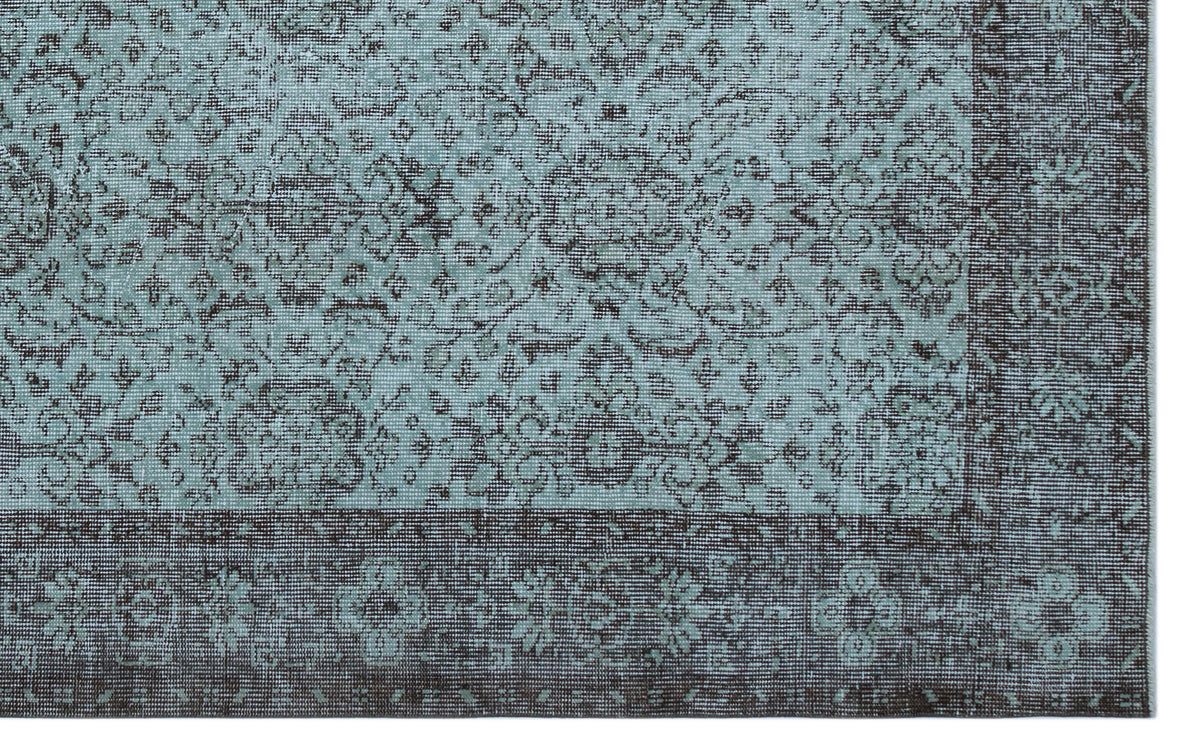Teal and charcoal grey rug with a distressed traditional floral medallion pattern and a wide decorative border.
