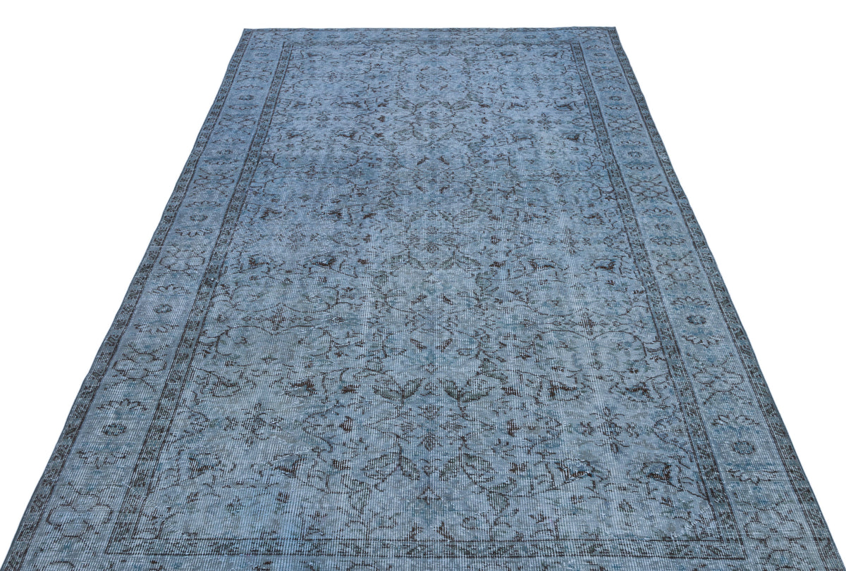 Blue and charcoal grey traditional rug with a distressed floral medallion pattern and a detailed border.