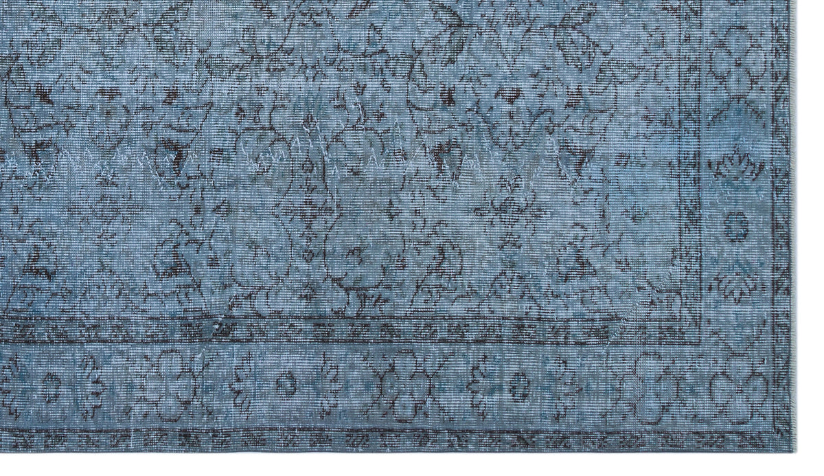 Distressed slate blue rug with a dark grey traditional floral medallion pattern and a detailed border.
