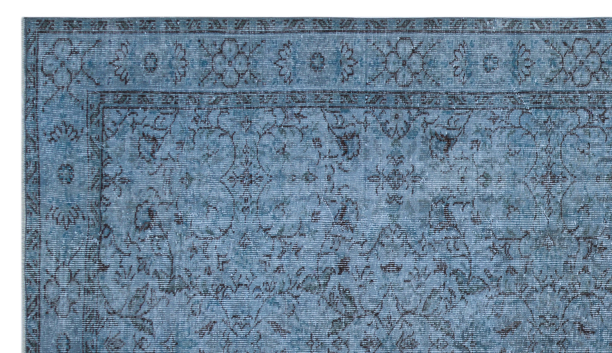 Blue and charcoal traditional rug with a distressed floral medallion pattern and a detailed border.