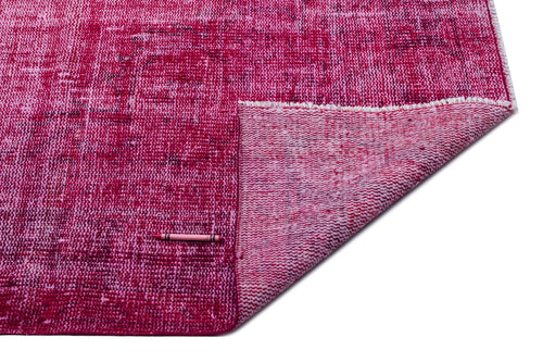 Load image 1 in gallery view. Distressed magenta and pink overdyed rug with a folded corner revealing the woven backing and a pink crayon for scale.
