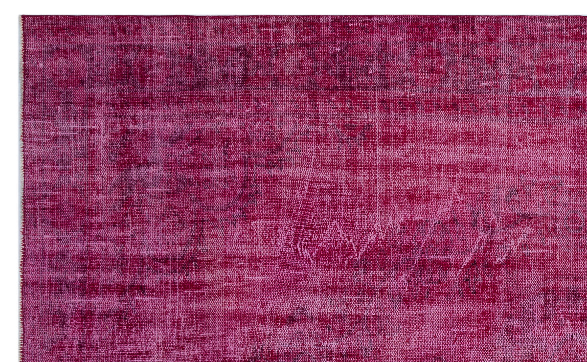 Magenta distressed overdyed rug with a faded, vintage-inspired texture.