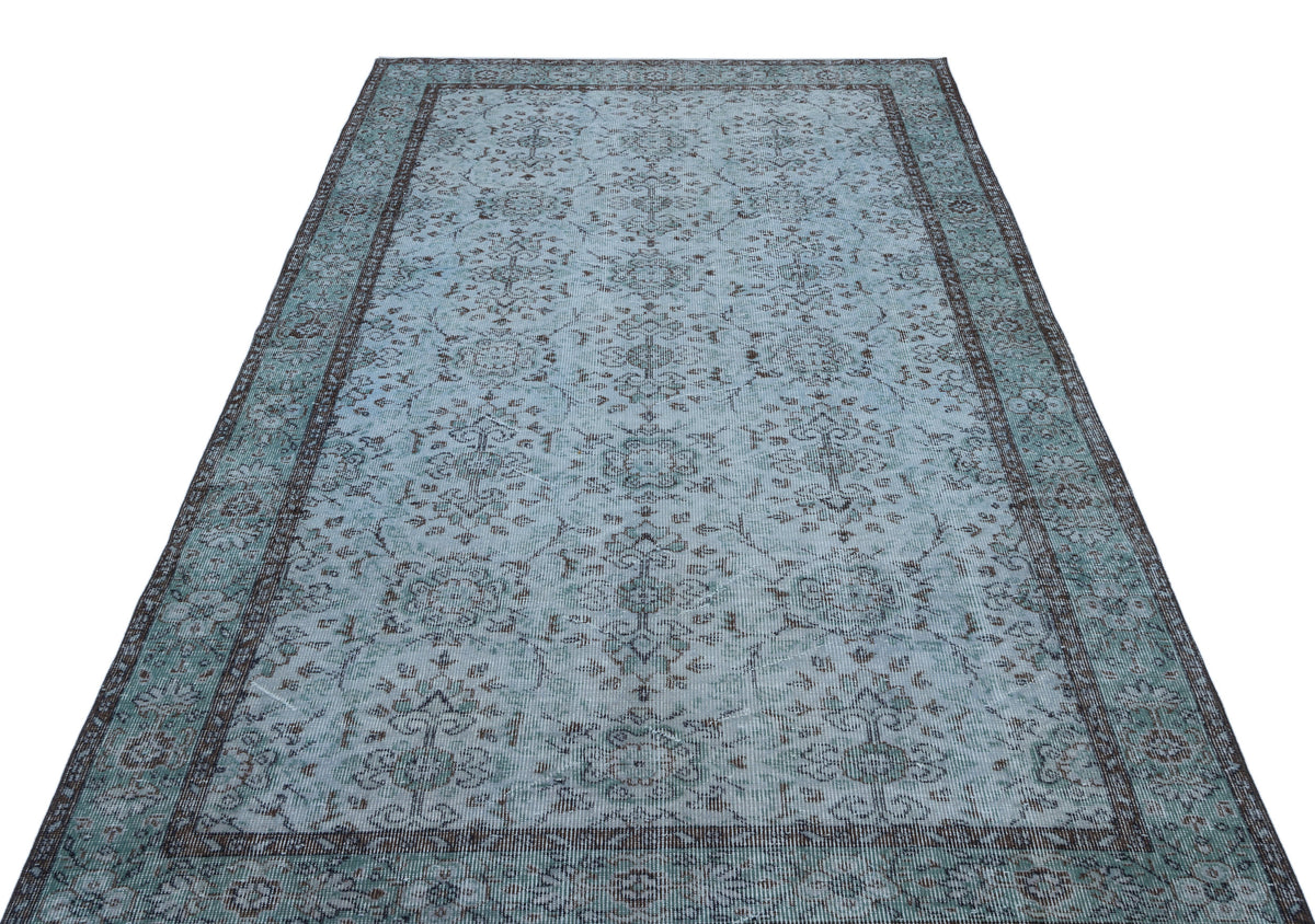 Light blue and charcoal distressed area rug with a traditional floral medallion pattern and a dark border.