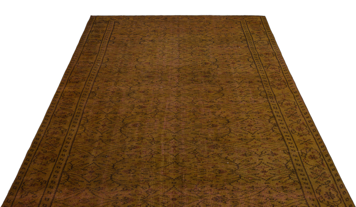Dark brown vintage-style rug with a repeating geometric lattice pattern and a decorative floral border.