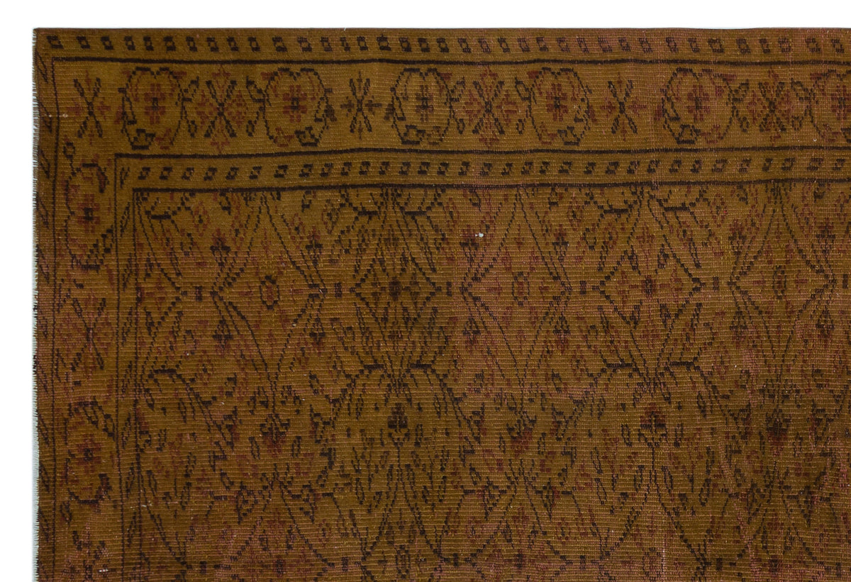 Mustard yellow and brown traditional rug with a geometric diamond lattice pattern and a decorative floral border.