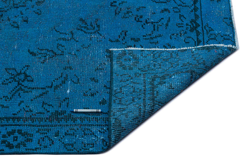 Load image 1 in gallery view. Turquoise blue rug with a distressed traditional floral pattern and a folded corner, isolated on a white background.