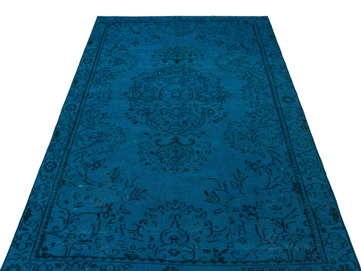 Deep blue rug with a black traditional floral medallion pattern on a white background.