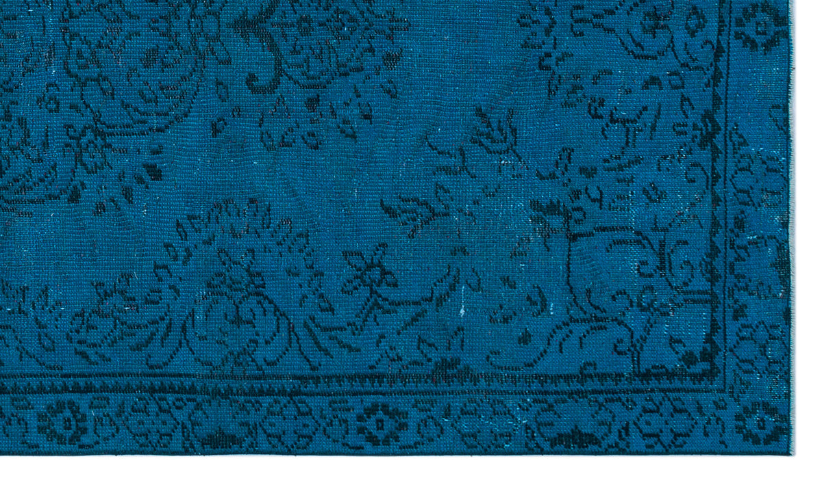 Deep teal rug with a black traditional floral medallion pattern and a detailed border.