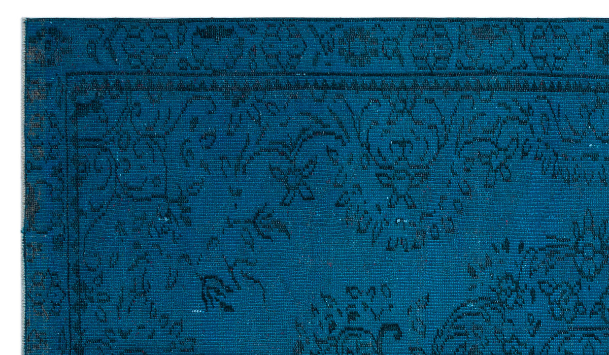 Deep teal rug with a black traditional floral medallion pattern and a detailed border.