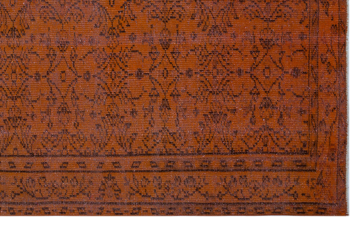 Rust-colored rug with a dark brown traditional floral medallion pattern and a geometric border.