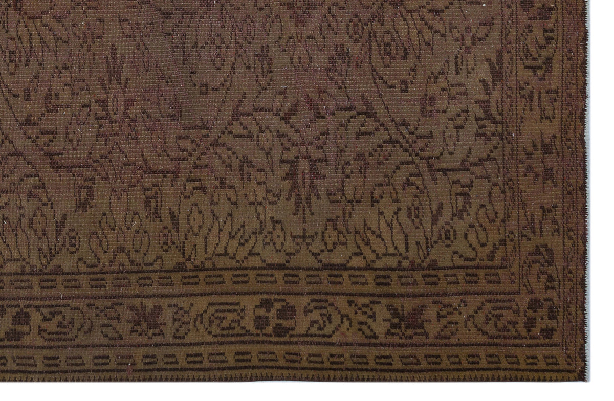 Dark brown traditional rug with a tonal floral medallion pattern and a geometric border.
