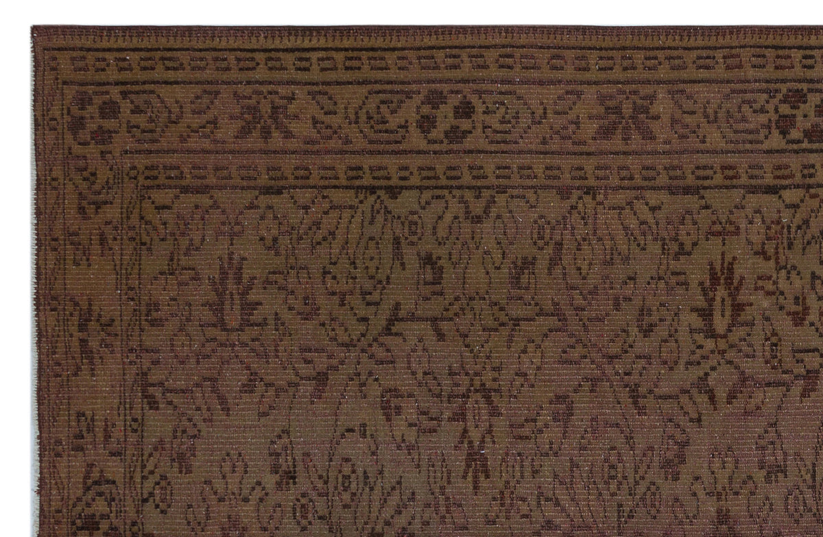 Dark brown traditional rug with a tonal floral pattern and a geometric border.