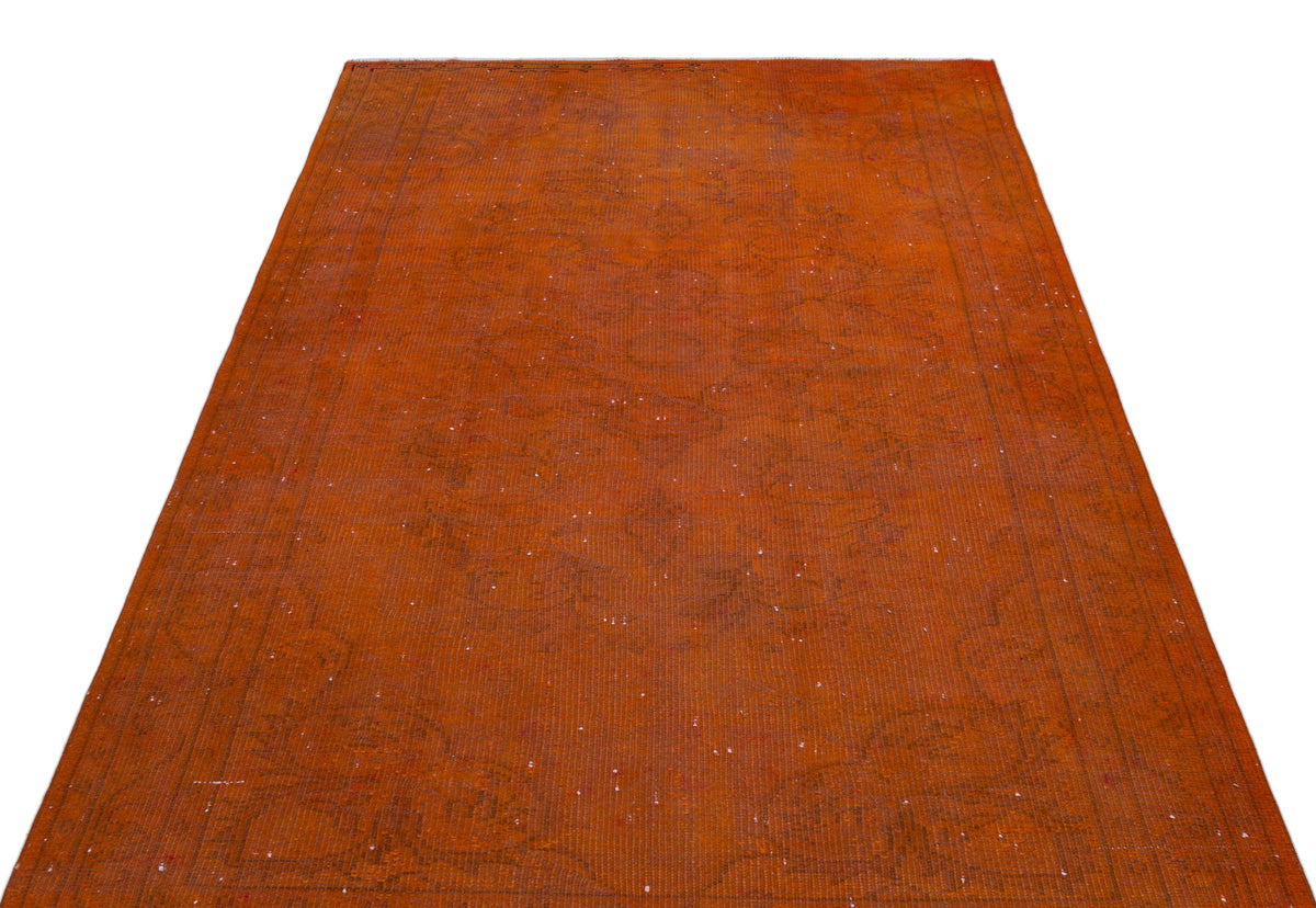 Rust-colored vintage-style rug with a faint, distressed traditional medallion pattern and a bordered edge.
