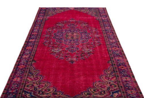 Load image 1 in gallery view. Magenta vintage-style rug with a central floral medallion and ornate border in blue and green tones.