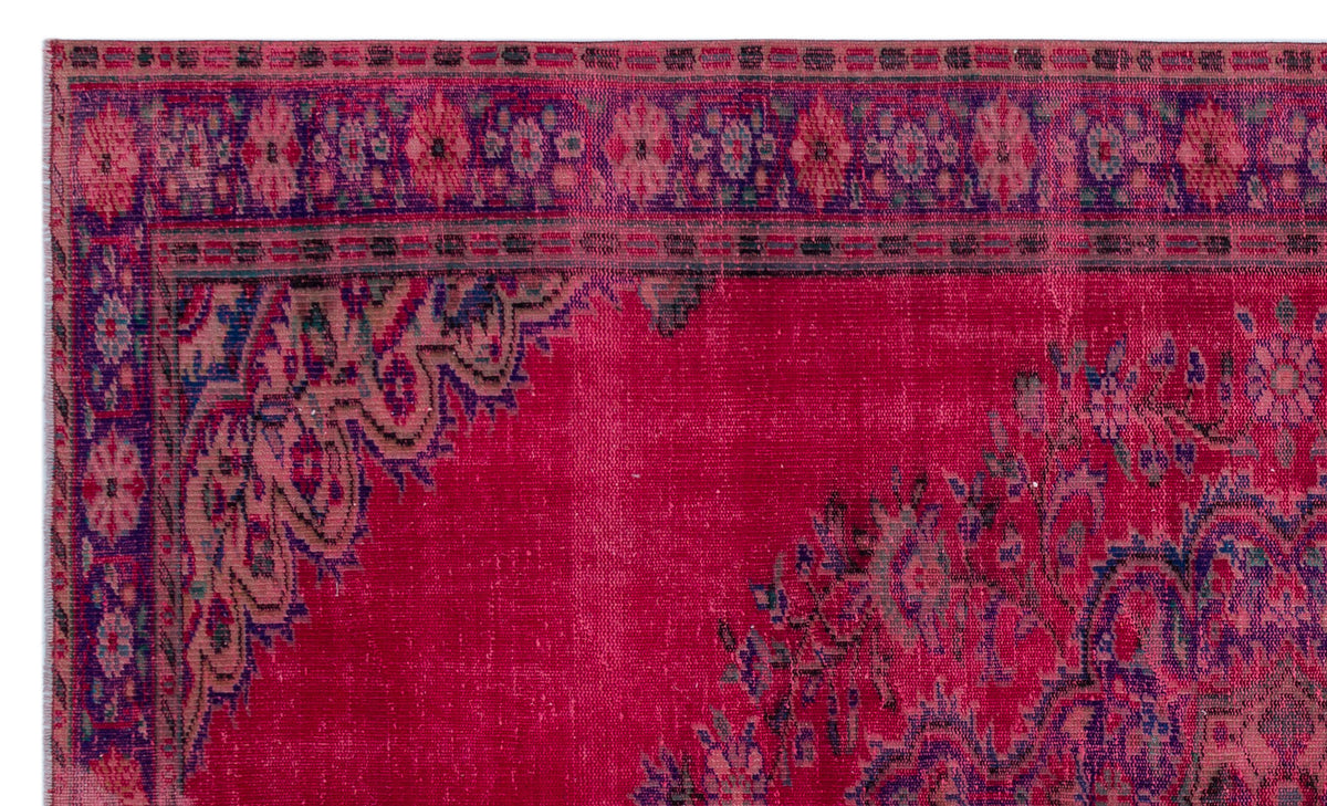 Magenta vintage-style rug with a dark purple floral border and intricate medallion corner pattern.