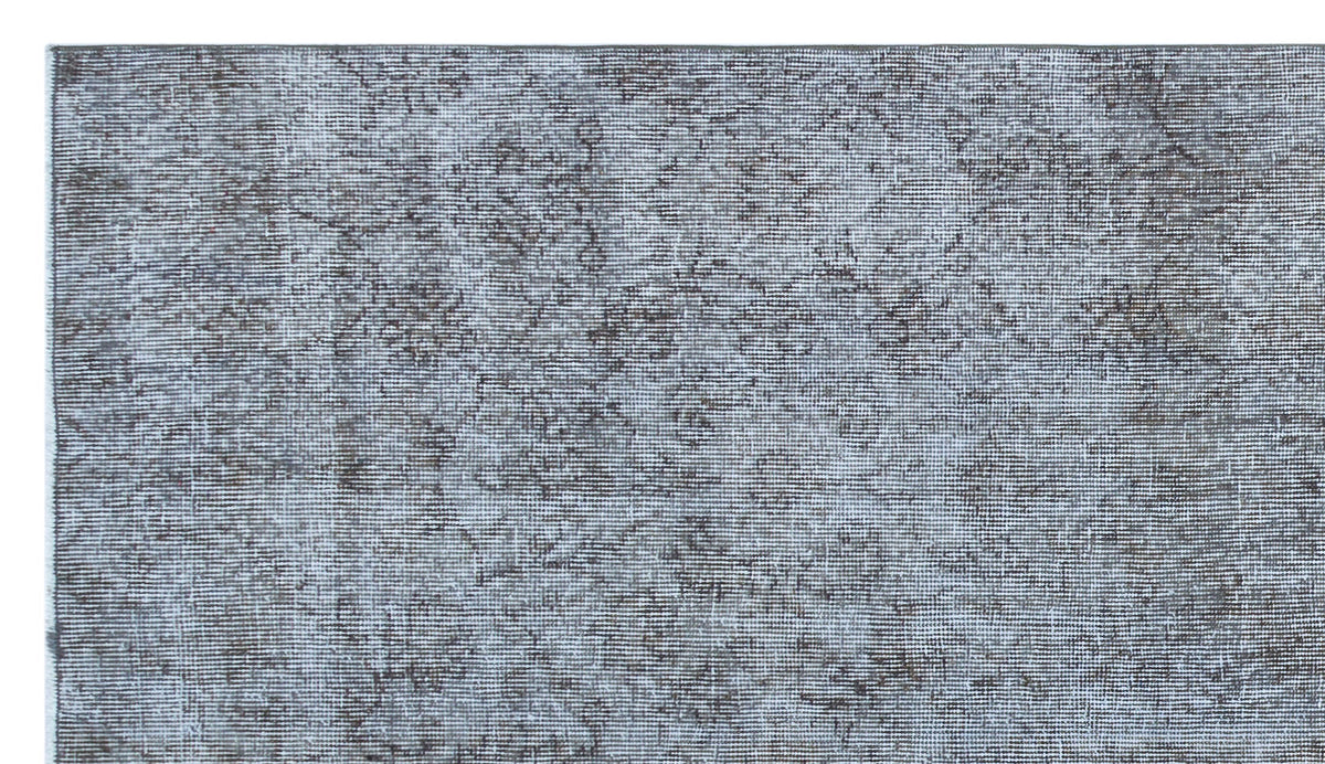 Grey and charcoal distressed rug with a faded traditional floral medallion pattern.