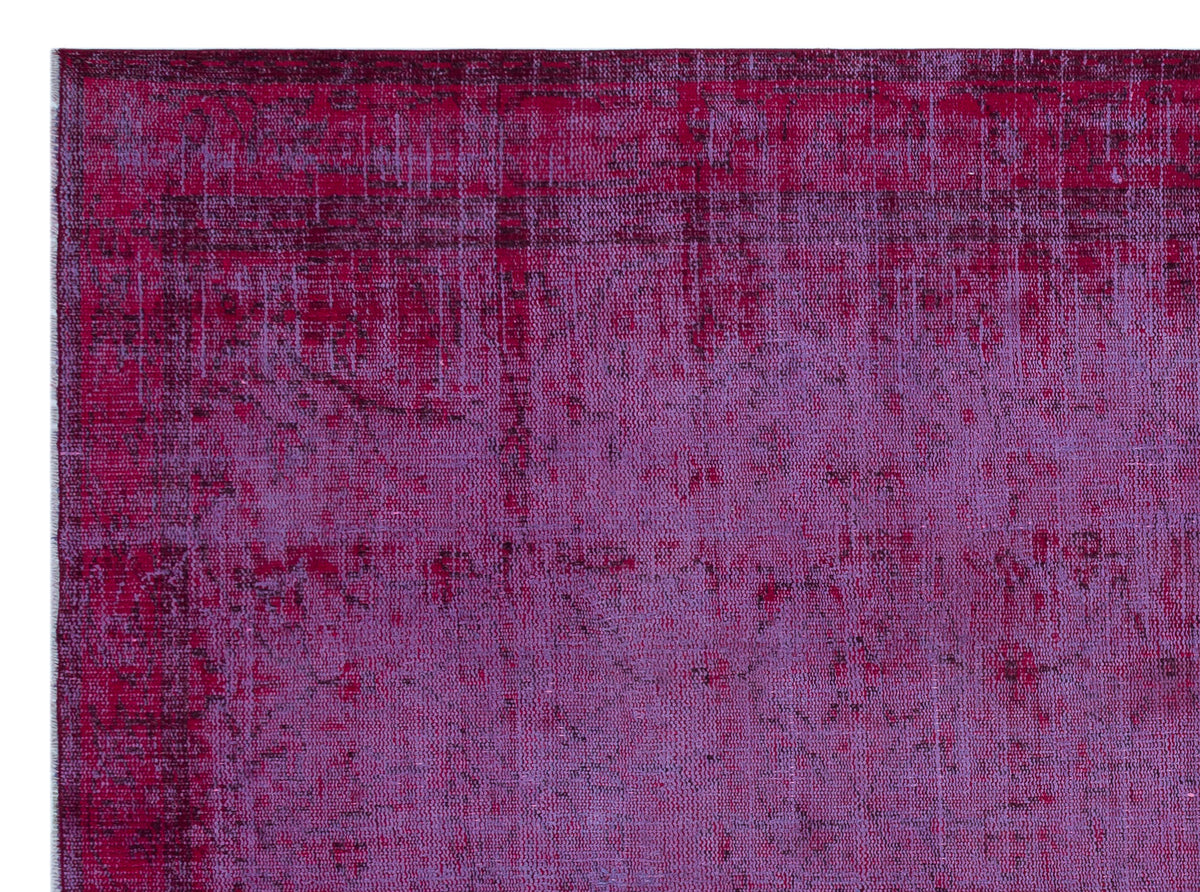 Magenta and purple distressed overdyed rug with a faded, textured pattern.