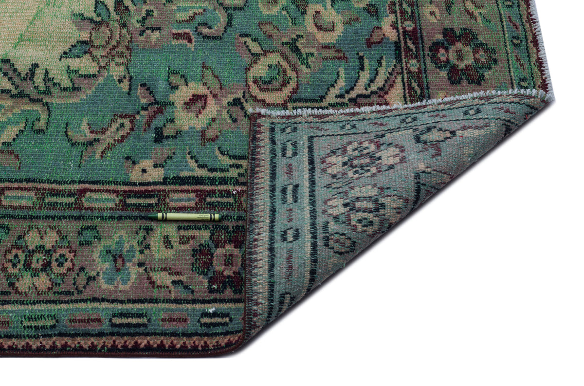 Teal and muted red traditional floral medallion rug with a folded corner on a white background.