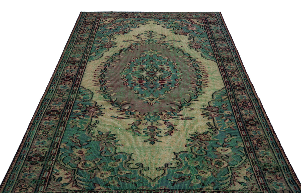Distressed green and beige traditional rug with a central floral medallion and ornate border on a white background.