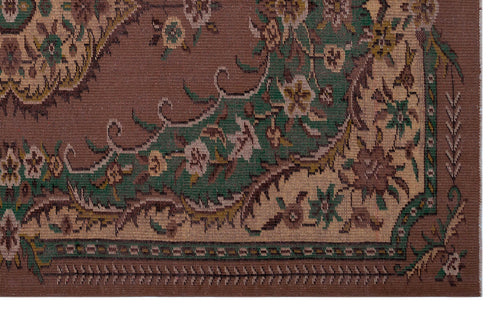 Load image 1 in gallery view. Brown traditional rug with a green and beige floral border and intricate vine-like patterns.