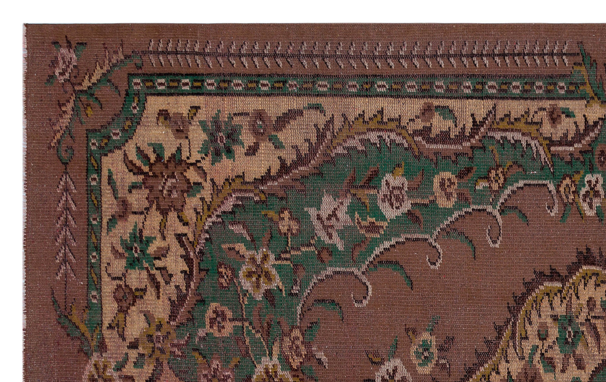 Brown traditional rug with a green and beige floral medallion border and intricate botanical motifs.
