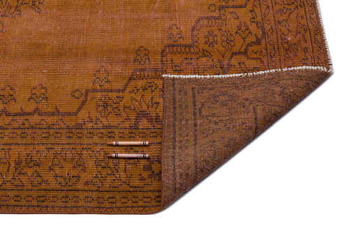 Load image 1 in gallery view. Rust-colored vintage rug with a dark brown floral border and a folded corner revealing the darker underside.