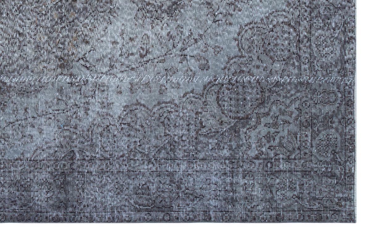Grey and charcoal distressed rug with a traditional floral medallion pattern and a detailed border.