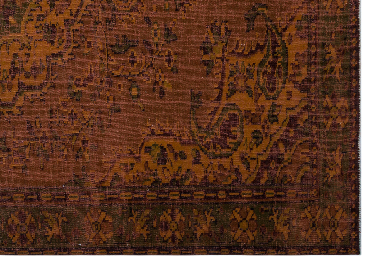 Rust and dark green traditional rug with a distressed floral paisley pattern and a geometric border.