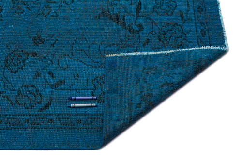 Load image 1 in gallery view. Teal rug with a dark grey floral medallion pattern, shown with a folded corner on a white background.