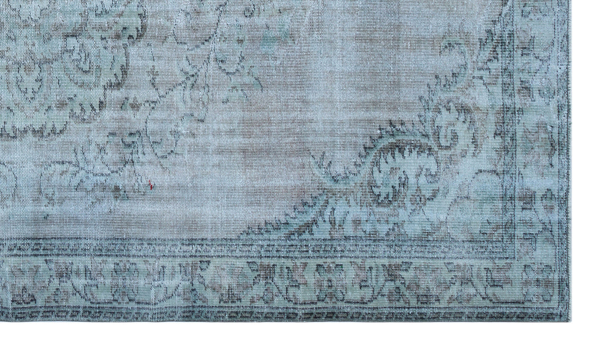 Distressed light blue and beige rug with a faded traditional floral medallion pattern and a detailed border.