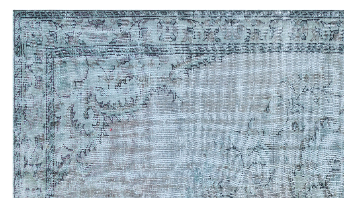 Distressed light blue and beige rug with a faded traditional floral border and central medallion pattern.